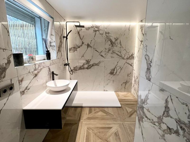 Un plafond blanc mat avec LEDs pour mettre en valeur une salle de bain en marbre